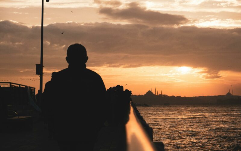 istanbul cityscape behind silhouette of man at sunset