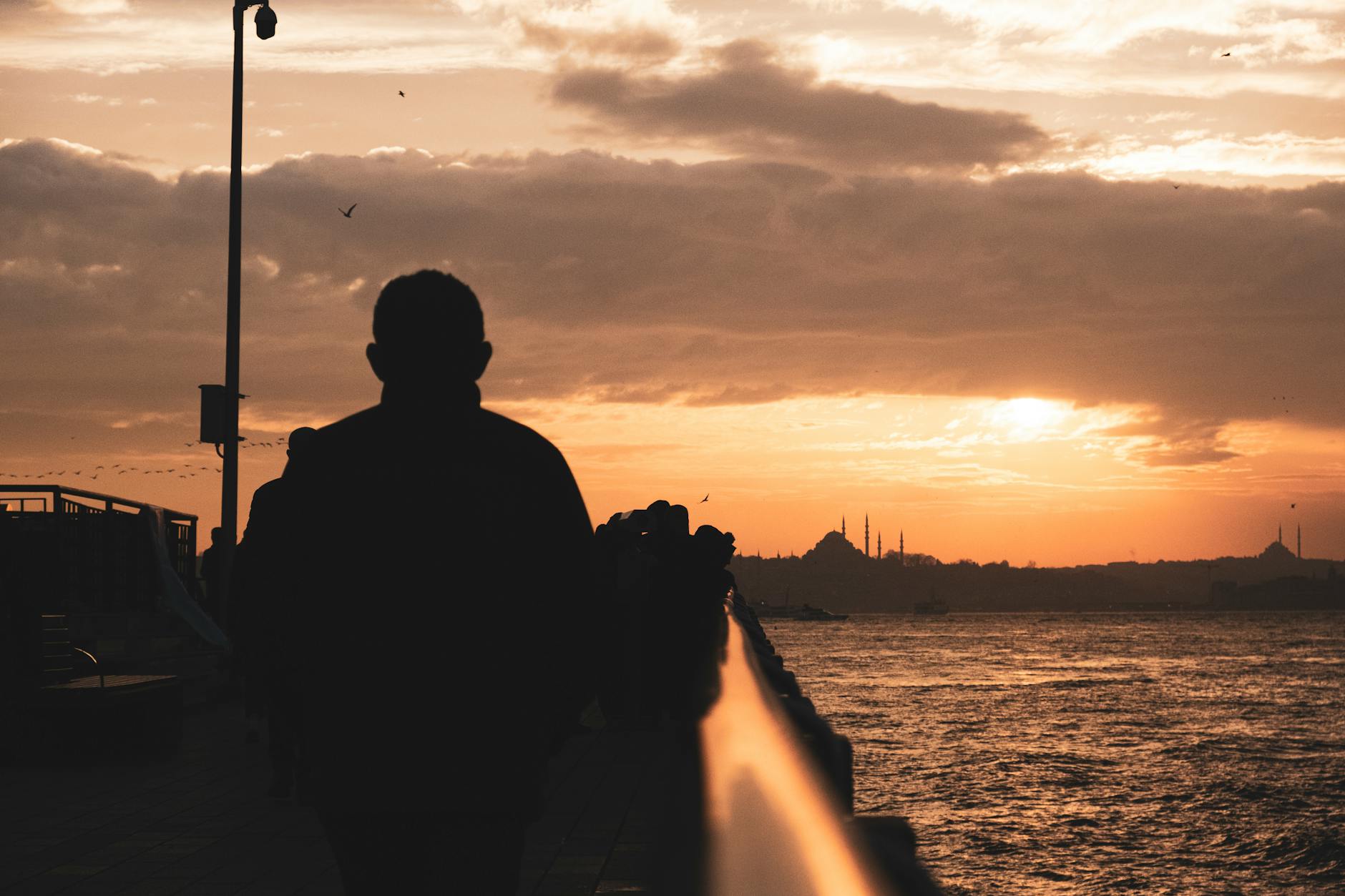 istanbul cityscape behind silhouette of man at sunset